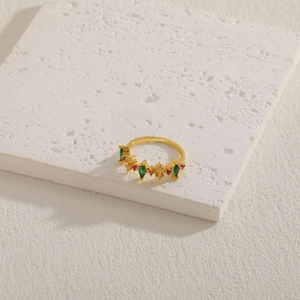 Detail of 14K gold plated ring with green leaf and red star zircons on a textured stone