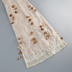 Vue macro détaillée de dentelle ivoire avec des fleurs 3D marron et des sequins