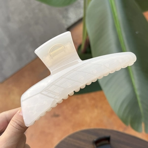 Minimalist large white acetate hair claw clip for women held in hand for size display