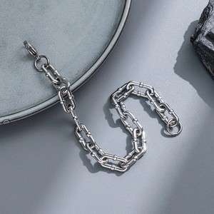Macro detail of silver stainless steel chain bracelet with lobster clasp on stone background