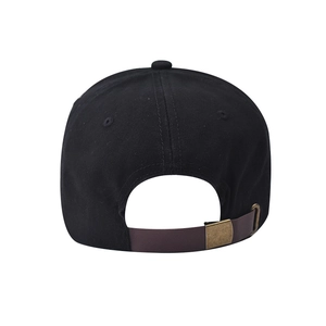 Detail view of cotton baseball cap featuring brown faux leather strap and bronze metal buckle