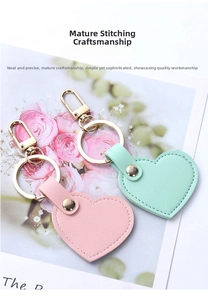Detail view of pink and mint green heart-shaped leather keychains with gold hardware