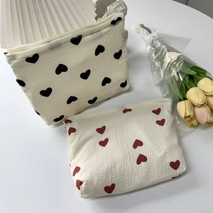 Detail of heart pattern storage bags in cream with black and red heart prints