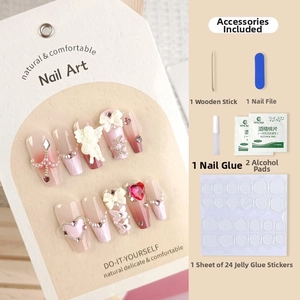 Close-up of pink and white press-on nails with 3D angel, pearls and bows plus tool kit