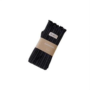 Knitted black wool arm warmers with ribbed texture and minimalist brand label