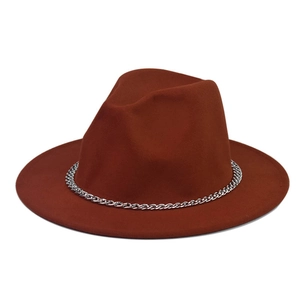 Detail of rust red wool fedora hat featuring a thick silver metal chain decoration
