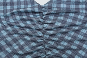 Gros plan détaillé du tissu à carreaux bleu et gris avec design froncé à cordon