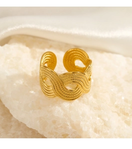 Detailed close-up of golden textured woven ring on white crystal stone with silk fabric