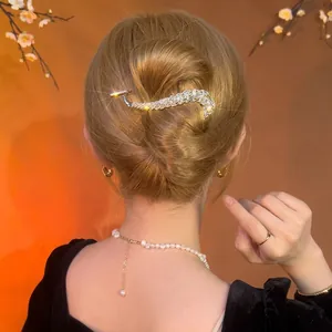Classic silver rhinestone crescent hair clip styled on an elegant bun hairstyle