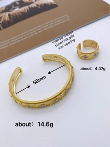 Detailed macro view of 18K gold-plated open bangle and ring with brushed floral engraving