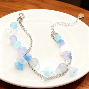Detalle de la pulsera de doble capa con cuentas de cristal azul y colgantes de corazón