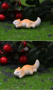 Detail of miniature resin squirrel sleeping on moss with fine fur texture for micro landscape