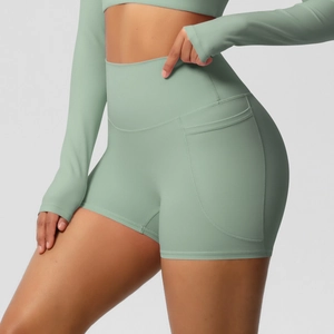 Gros plan sur un short de yoga taille haute vert sauge avec poches latérales pratiques