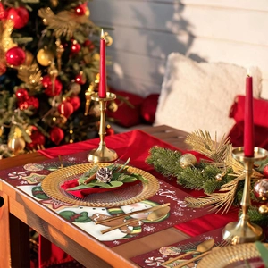 Christmas placemats featuring snowmen and gingerbread men on a wooden table setup