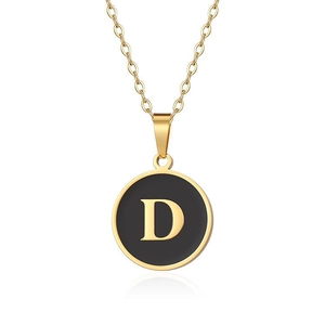 Dettaglio collana dorata con ciondolo tondo in smalto nero e lettera D in oro