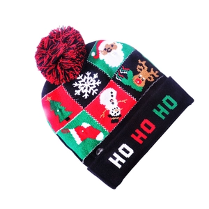 Detail of knitted Christmas hat with LED lights, snowflakes, and HO HO HO pattern