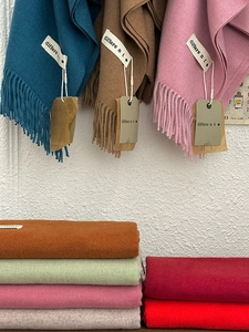 Close-up of multicolored cashmere-feel scarves featuring elegant fringed edge details
