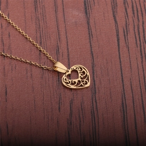 Gold heart pendant necklace with intricate filigree cutouts and elegant curb chain