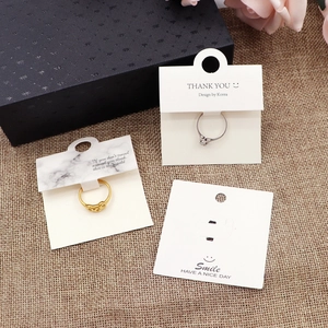 Close-up of marble pattern paper ring display card with Thank You text on black gift box