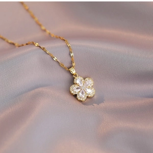 Elegant gold flower necklace with zircon petals on pink silk background for women