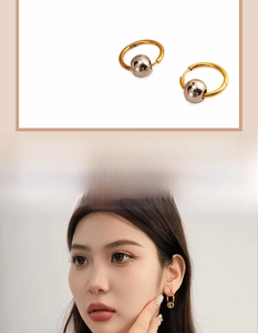 Détail de boucles d'oreilles créoles en acier inoxydable avec perle dorée sur mannequin