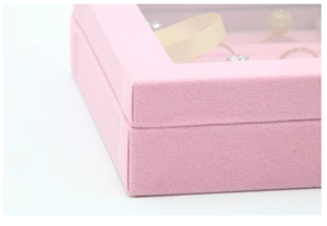 Close-up of pink velvet jewelry box showing fine texture and transparent glass lid