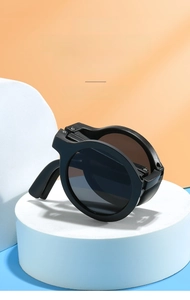 Detail view of foldable black round sunglasses for kids on a modern orange and blue background