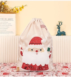 Detail of Santa Claus printed canvas gift bag with drawstring on red plaid tablecloth