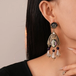 Vintage palace style teardrop earrings with crystals and iris center on a model