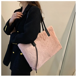 Dettaglio borsa tote in ecopelliccia rosa con spalline in pelle nera su modella