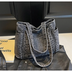Close-up of washed denim tote bag showing acid wash texture and side pocket detail