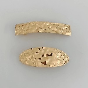 Set of two gold metal hair clips with geometric oval shapes and hammered vintage texture