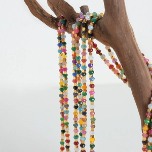 Handmade multi-color faceted tourmaline beaded necklace with gold spacer beads on driftwood