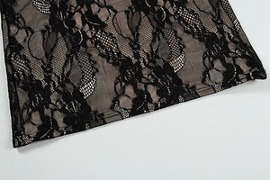 Detail shot of intricate black floral lace with contrast nude lining on evening dress