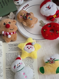 Flat lay of assorted Christmas plush charms including Santa, Reindeer and Gingerbread man