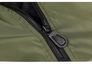Vue macro d'une fermeture éclair noire avec tirette en cuir sur une veste verte