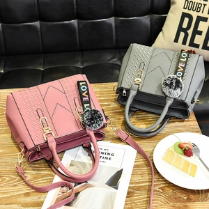 Litchi pattern leather handbags with pompom charms and logo straps in soft pink and grey