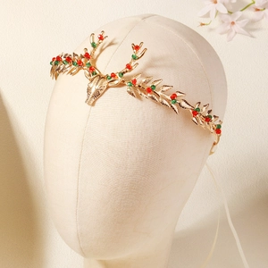 Close-up of golden reindeer antler headband with red and green crystals for Christmas