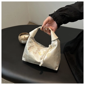 Detailed embroidery on a Chinese-style jacquard handbag with silk-like satin finish