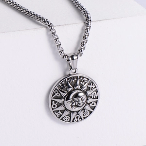 Gros plan d'un pendentif soleil et lune avec signes du zodiaque et finition punk vieillie