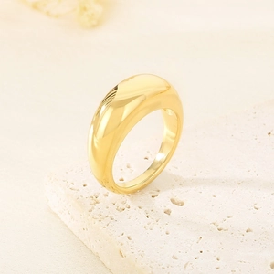 Polished gold stainless steel minimalist ring placed on a textured stone display