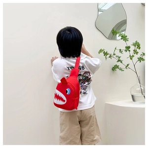 Detail view of the red shark chest bag for kids with white teeth and cartoon features