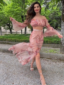 Detail of pink floral two-piece set featuring off-shoulder crop top and high slit skirt