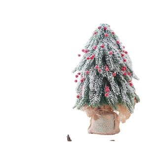 Mini tabletop snowy Christmas tree with red berries and a rustic burlap wrapped base