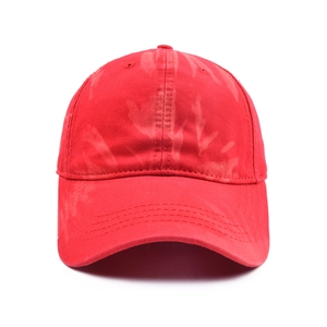 Detail of dark red cotton baseball cap showing unique tie-dye texture and curved brim