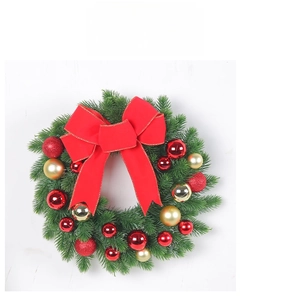 Close-up of artificial Christmas wreath with large red bow and festive gold ornaments