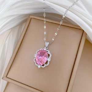 Macro view of silver necklace featuring an oval pink gemstone with sparkling diamond halo