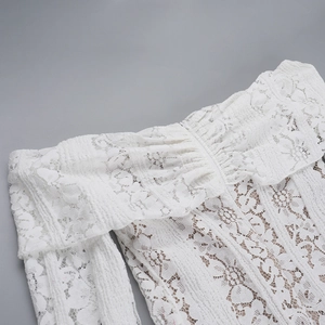 Detail of white lace off-shoulder dress featuring intricate floral hollow-out textures