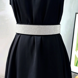 Close-up of sparkling silver rhinestone wide belt with elastic black backing on a dress