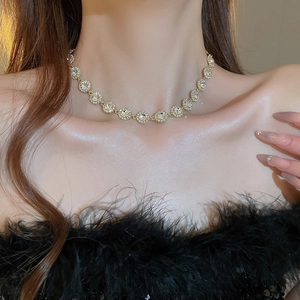 Gros plan d'un collier en or étincelant avec diamants pavés ronds porté par un mannequin